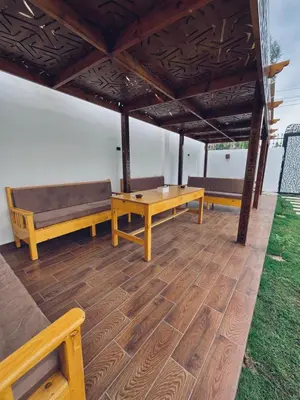 a pavilion with benches and a table and a wooden floor at Farah Hotel in Al Aqālitah