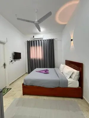 a bedroom with a bed and a ceiling fan at Farah Hotel in Al Aqālitah