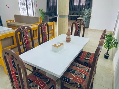 a white table with chairs and a box on it at Farah Hotel in Al Aqālitah