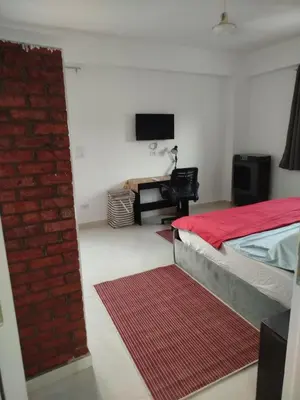 a bedroom with a bed and a red brick wall at Villa-Djorf Westbank in Al Aqālitah