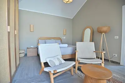 a bedroom with a bed and two chairs and a table at Bali - ELGOUNA - Premium Chalet with private pool in Hurghada