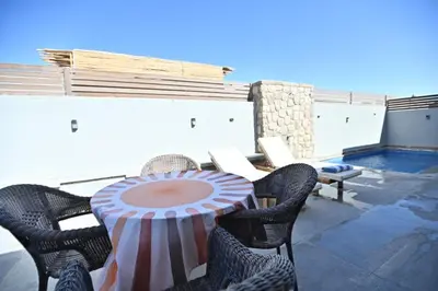 a patio with a table and chairs and a pool at Bali - ELGOUNA - Premium Chalet with private pool in Hurghada