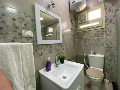 a bathroom with a sink and a toilet and a mirror at Flat on the Sea in Hurghada