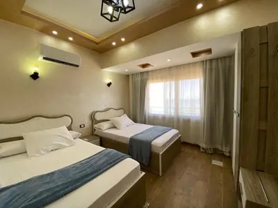 a hotel room with two beds and a window at Flat on the Sea in Hurghada
