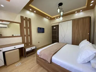 a bedroom with a large bed and a television at Flat on the Sea in Hurghada