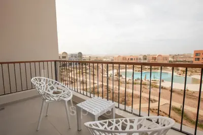 a balcony with chairs and a view of a pool at Ladybird - Kamaran Pearl in Hurghada