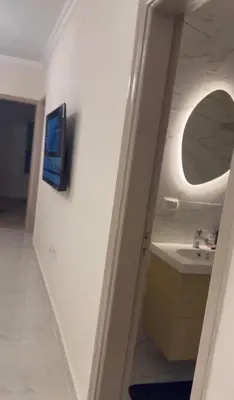 a bathroom with a sink and a mirror on a wall at Stylish home & Free transfers in Hurghada