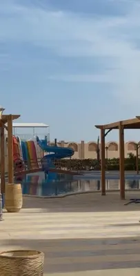 a pool with chairs and tables in a resort at Stylish home & Free transfers in Hurghada