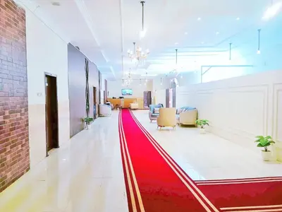 a hallway with a red carpet in a room at VIP hotel & café in Qilfāw