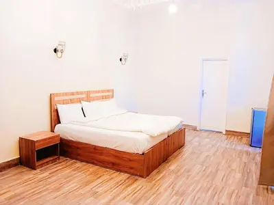 a bedroom with a bed and a wooden floor at VIP hotel & café in Qilfāw