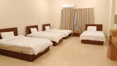 a room with three beds and a television in it at VIP hotel & café in Qilfāw