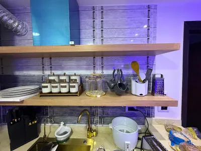a kitchen with a sink and a shelf with utensils at Hub Hurghada Two Bedroom Luxury Apartment in Hurghada