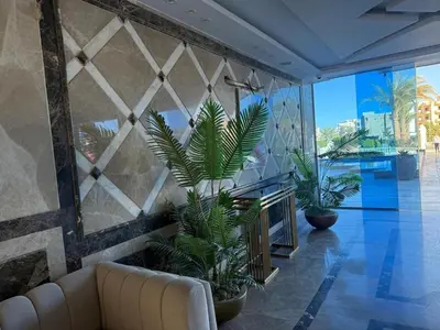 a living room with a couch and some plants at Hub Hurghada Two Bedroom Luxury Apartment in Hurghada
