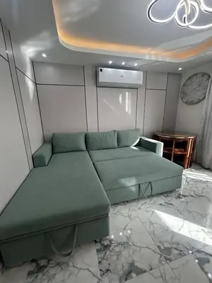 a living room with a green couch and a table at Hub Hurghada Two Bedroom Luxury Apartment in Hurghada