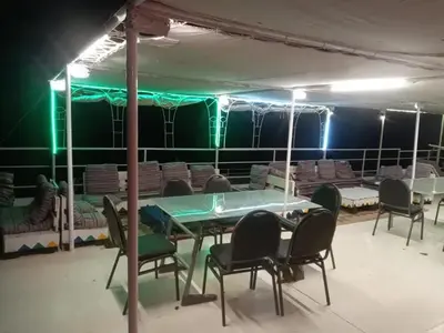 a table and chairs in a room with green lights at Shellaly Ca Nubian Heritage House in Jazīrat Salūjah