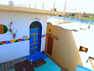 a house with a blue door on the side of it at Shellaly Ca Nubian Heritage House in Jazīrat Salūjah