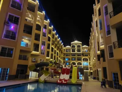 a swimming pool with a slide in front of a building at فندق جوليانا بيتش in Hurghada