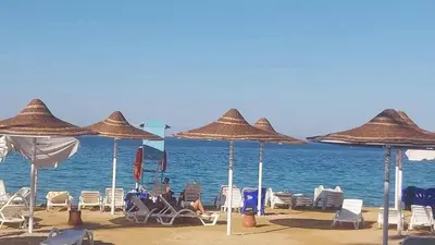 a group of chairs and umbrellas on a beach at فندق جوليانا بيتش in Hurghada