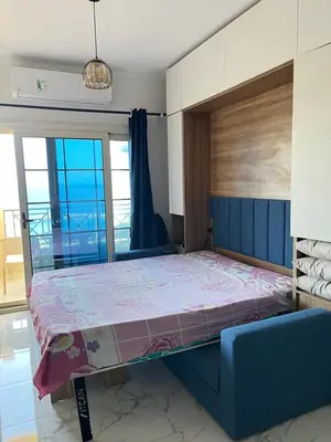 a bedroom with a bed and a blue couch at Juliana Beach Resort, Hurghada in Hurghada