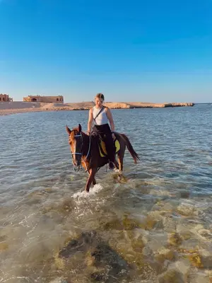 a woman riding a horse in the water at Horse Riding Tour in Hurghada