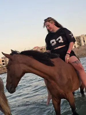 a woman riding a horse in the water at Horse Riding Tour in Hurghada
