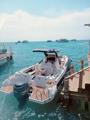 a white boat parked next to a dock in the water at Speed Boat Tour Hurghada 4 Hours in Hurghada