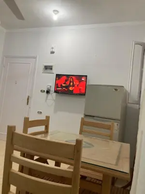 a dining room with a table and a refrigerator at عماره المهندس in Hurghada