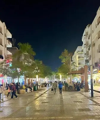 a group of people walking down a street at night at عماره المهندس in Hurghada
