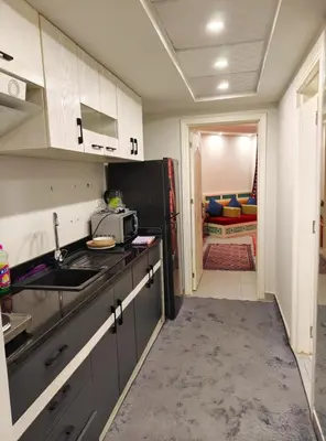 a kitchen with a sink and a black refrigerator at Holiday Seaview Home I Near Palacio Hotel I WIFI in Hurghada