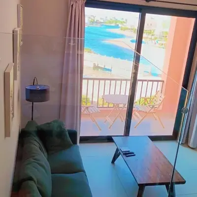 a living room with a couch and a view of the ocean at Yoke 2 bedrooms Duplex Tawila ElGouna, Plaza gouna in Hurghada