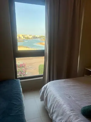 a bedroom with a window with a view of a field at Yoke 2 bedrooms Duplex Tawila ElGouna, Plaza gouna in Hurghada