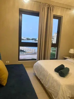 a bedroom with a bed and a large window at Yoke 2 bedrooms Duplex Tawila ElGouna, Plaza gouna in Hurghada