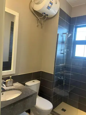a bathroom with a toilet and a shower and a sink at Yoke 2 bedrooms Duplex Tawila ElGouna, Plaza gouna in Hurghada