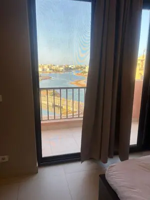a bedroom with a view of a balcony with a window at Yoke 2 bedrooms Duplex Tawila ElGouna, Plaza gouna in Hurghada