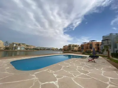 a swimming pool with a chair and an umbrella at Lovely 1 bd apartment with amazing view in Tawila in Hurghada