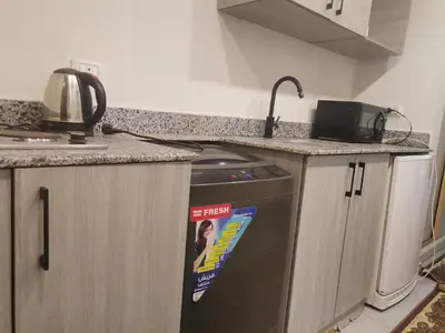 a kitchen with a dishwasher and a counter top at Modern Downtown Apartment In Scandic Resort WiFi Beach Front in Hurghada
