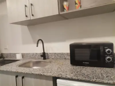 a kitchen counter with a sink and a microwave at Modern Downtown Apartment In Scandic Resort WiFi Beach Front in Hurghada