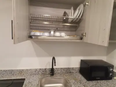a kitchen counter with a sink and a microwave at Modern Downtown Apartment In Scandic Resort WiFi Beach Front in Hurghada