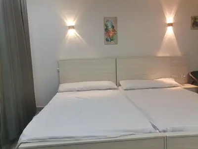 two beds in a bedroom with two lights above them at Modern Downtown Apartment In Scandic Resort WiFi Beach Front in Hurghada