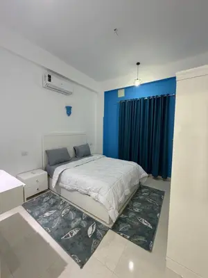 a bedroom with a large bed with a blue wall at Secrets Of The Nile in Luxor