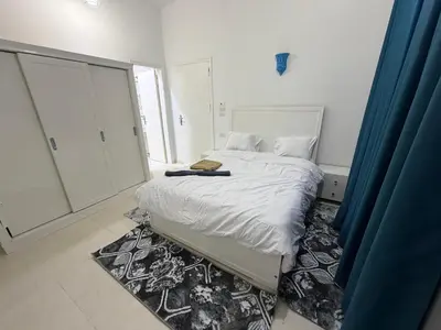 a bedroom with a white bed with a rug at Secrets Of The Nile in Luxor