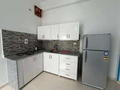a kitchen with white cabinets and a refrigerator at Secrets Of The Nile in Luxor