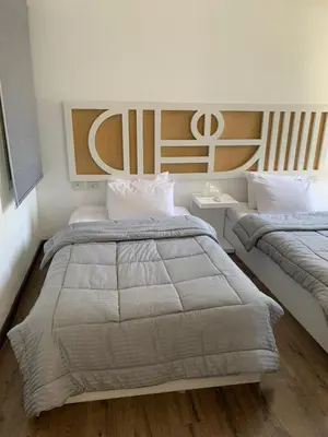 a bedroom with two beds and a headboard at 2bd direct on the main pool in Hurghada