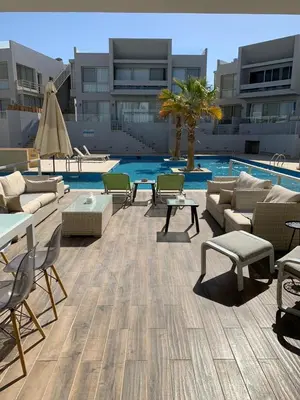 a patio with couches and chairs and a pool at 2bd direct on the main pool in Hurghada