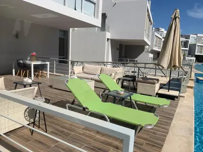 a deck with chairs and tables and a pool at 2bd direct on the main pool in Hurghada