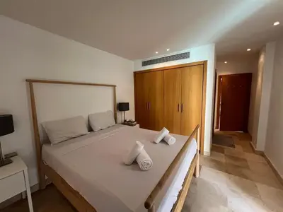 a bedroom with a large bed with two pillows on it at 2bd direct on the pool in Scarab El Gouna in Hurghada