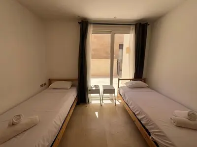 two beds in a room with a window at 2bd direct on the pool in Scarab El Gouna in Hurghada