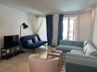 a living room with a blue couch and chairs at 2bd direct on the pool in Scarab El Gouna in Hurghada