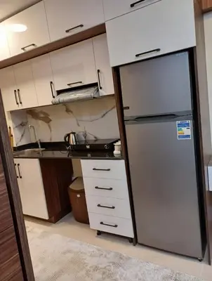 a kitchen with a refrigerator and white cabinets at Tiba Golden Resort Hurghada in Hurghada