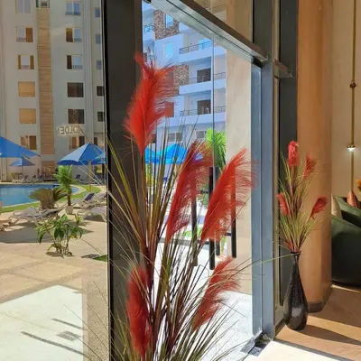 a glass wall with a palm tree in a hotel lobby at Tiba Golden Resort Hurghada in Hurghada